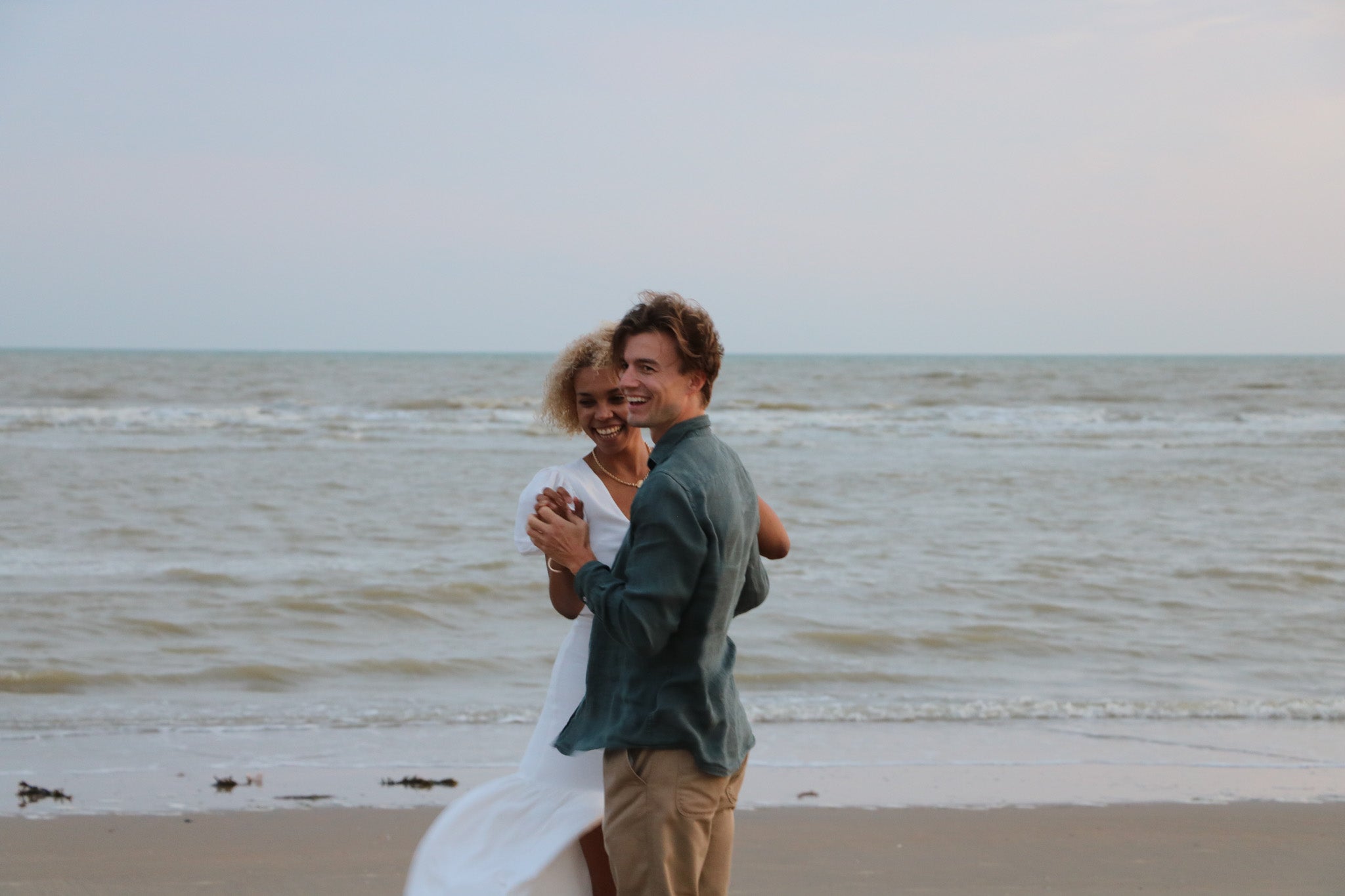 A couple by the sea holding hands