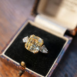 Diamond ring in an open jewelry box on a wooden surface