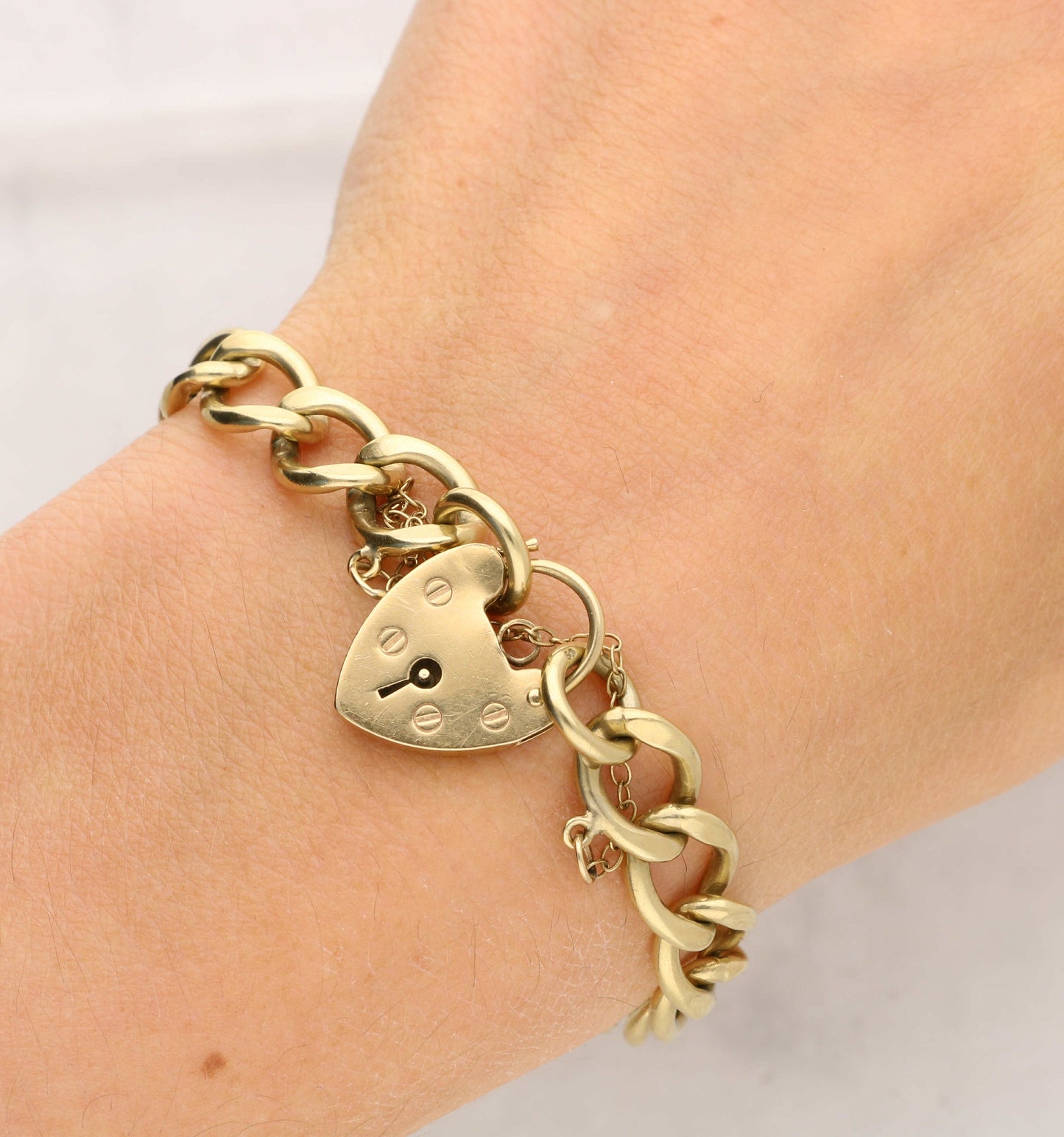 9ct gold curb bracelet with heart padlock.